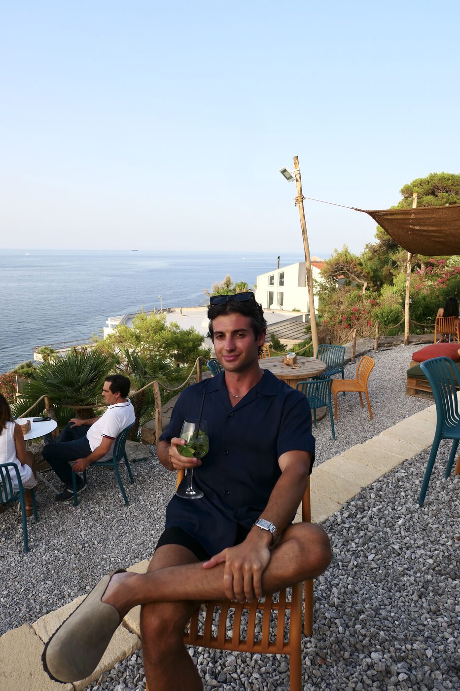 Gio Mineo — navy polo, seaside table