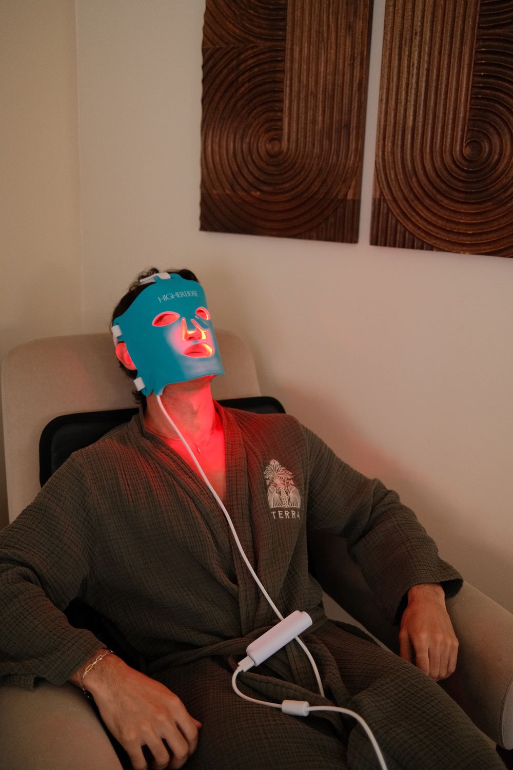 HigherDose red light mask in a Terra robe